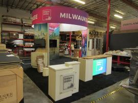 ECO-4100 Sustainable Island Exhibit with Curved Canopies, Backlit Lightboxes, Tower with Closet Storage, Multiple Monitor Mounts, ECO-8C Podium, ECO-42C Reception Counter and Locking Storage. Reconfigures to 10 x 10 and 10 x 20 designs